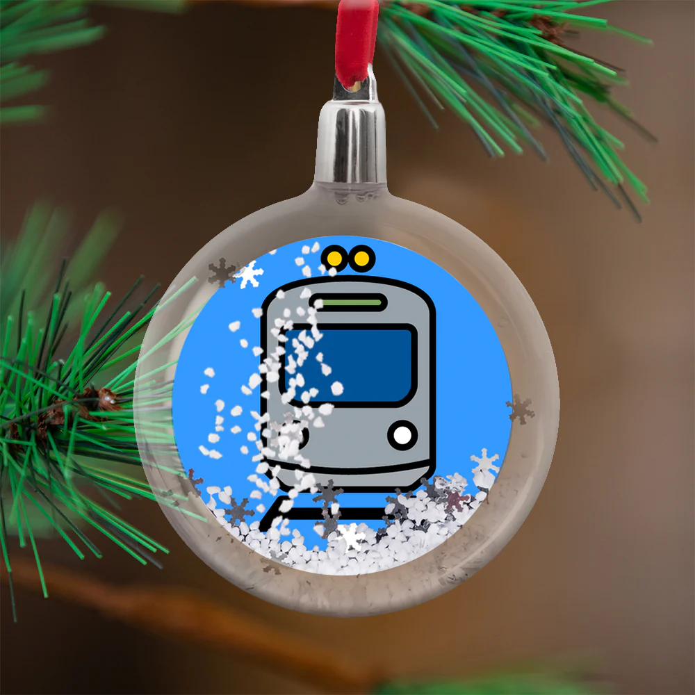 image of a christmas tree ornament with a cartoon train surrounded by snowflakes